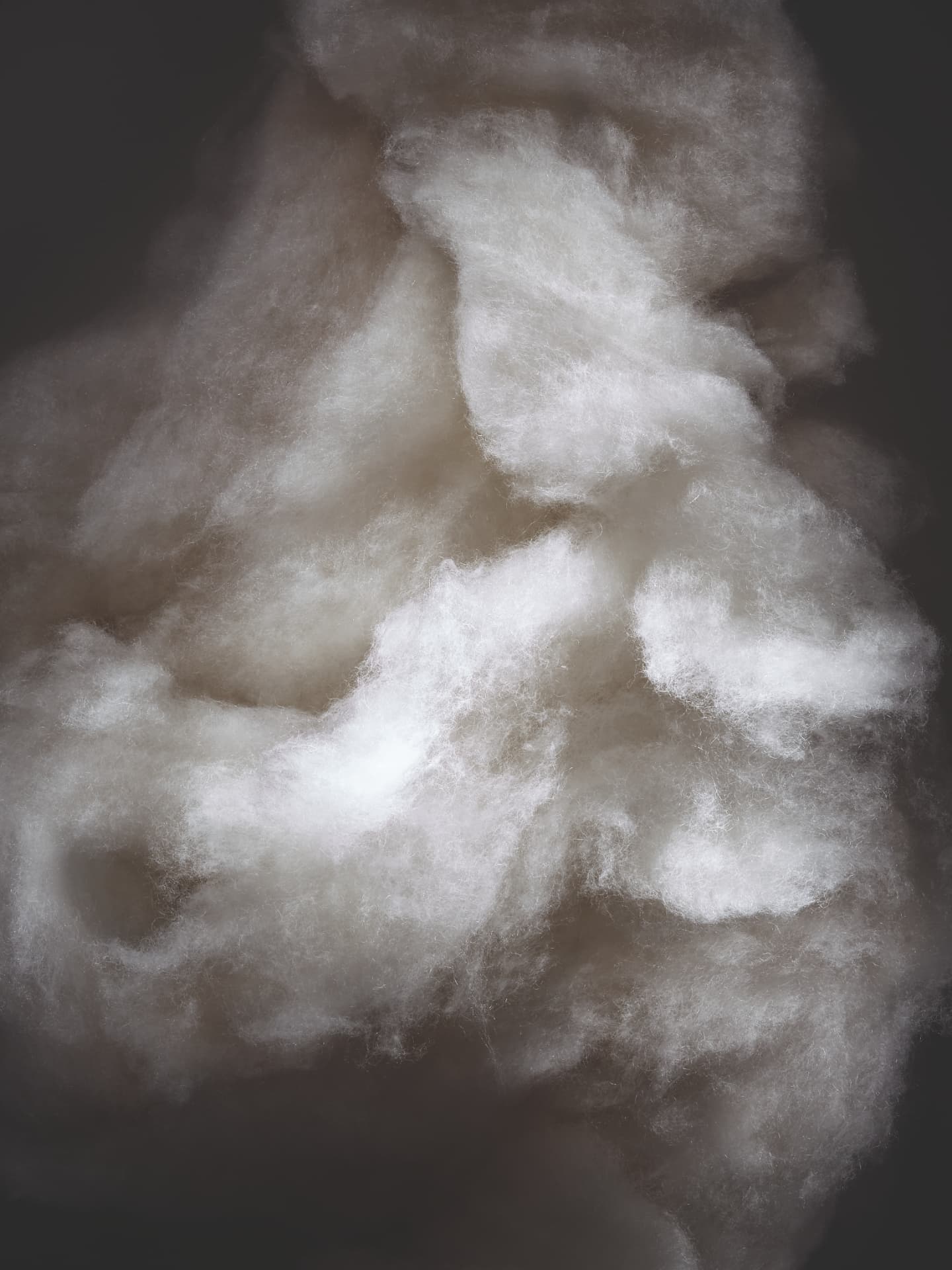 Soft white cashmere fibres catching the light against a dark background