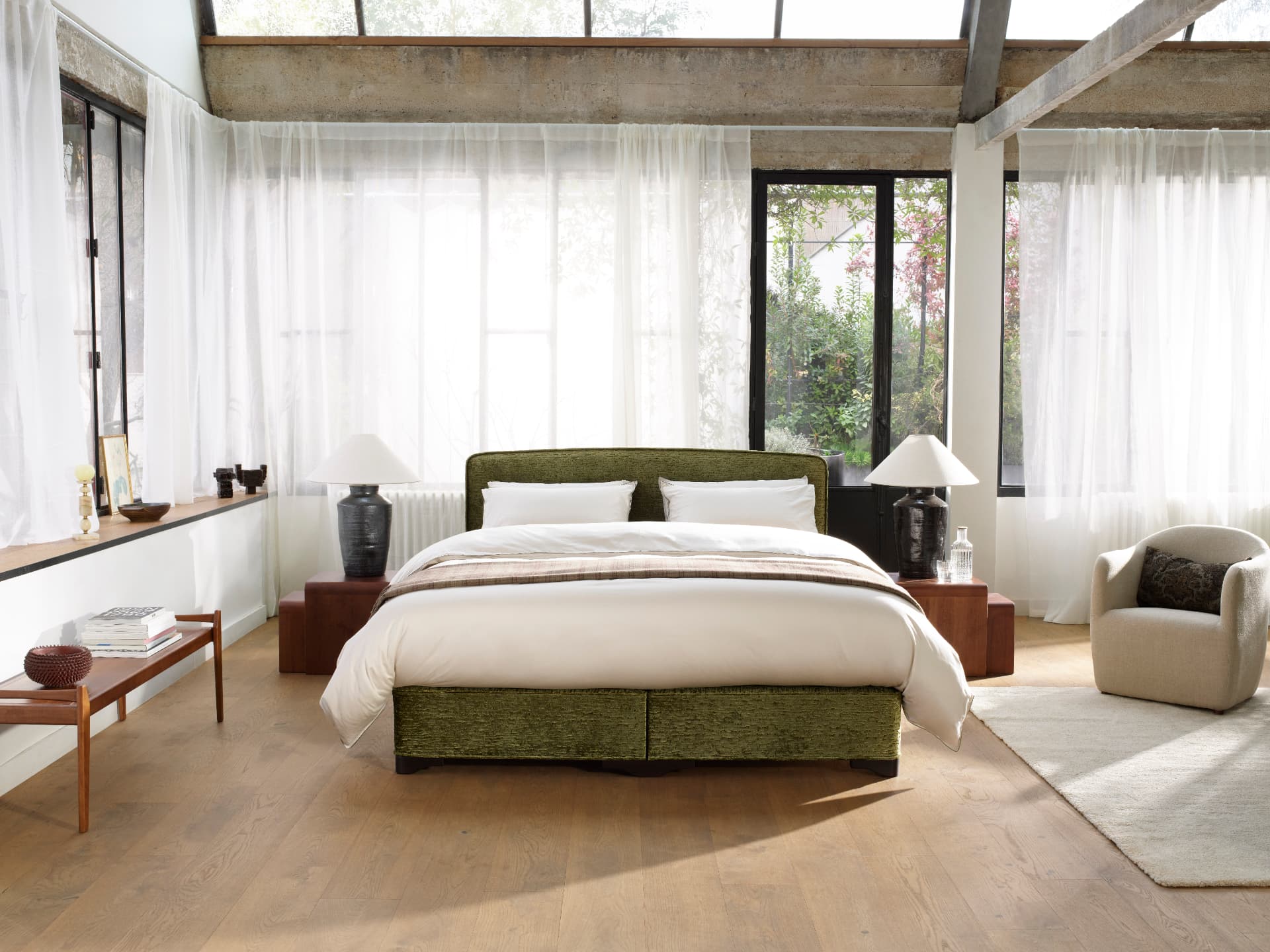 A Classic Collection bed upholstered in olive chenille in a bright garden room