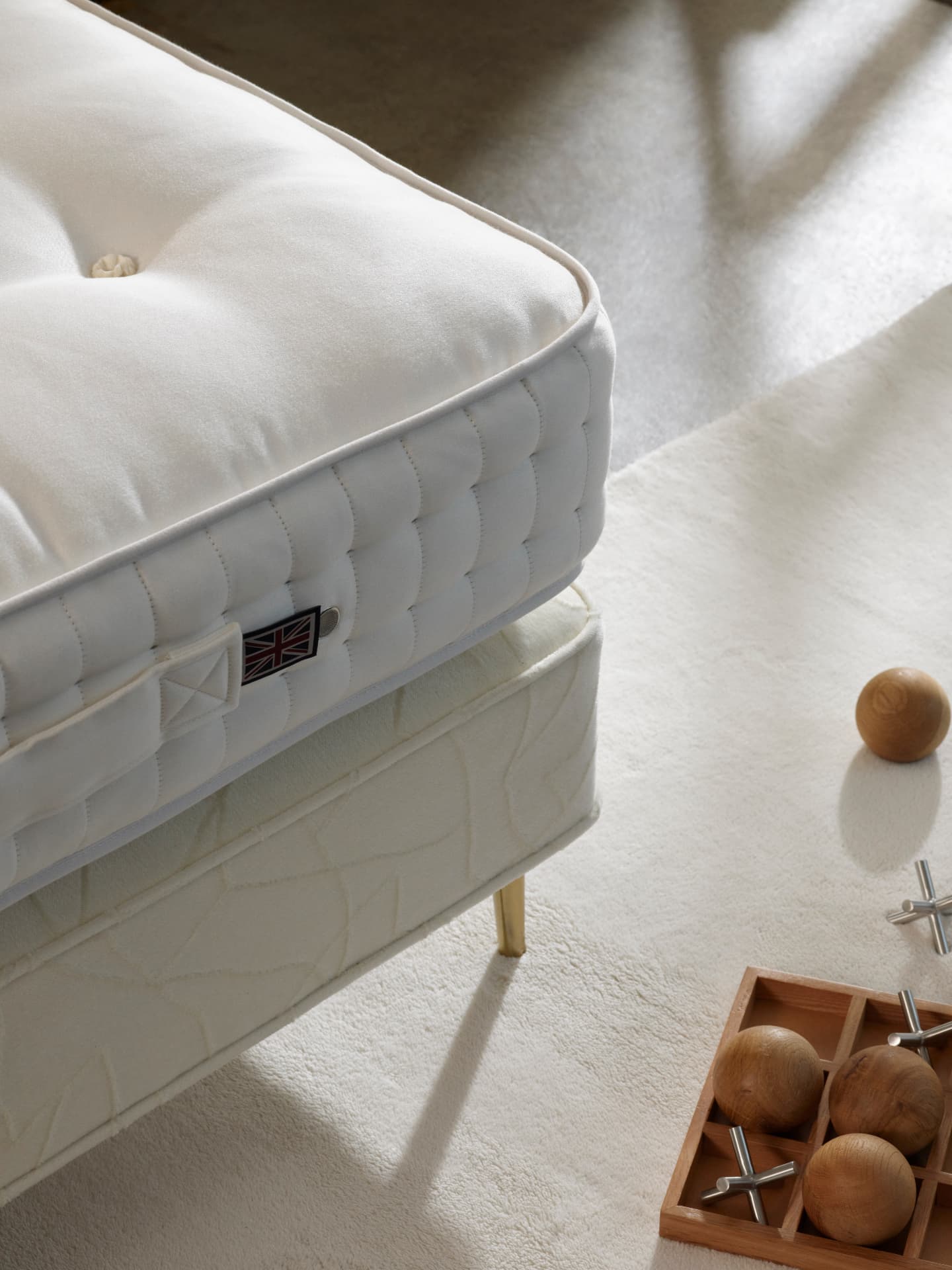 Close detail of a hand-tufted Vispring mattress edge above its divan base