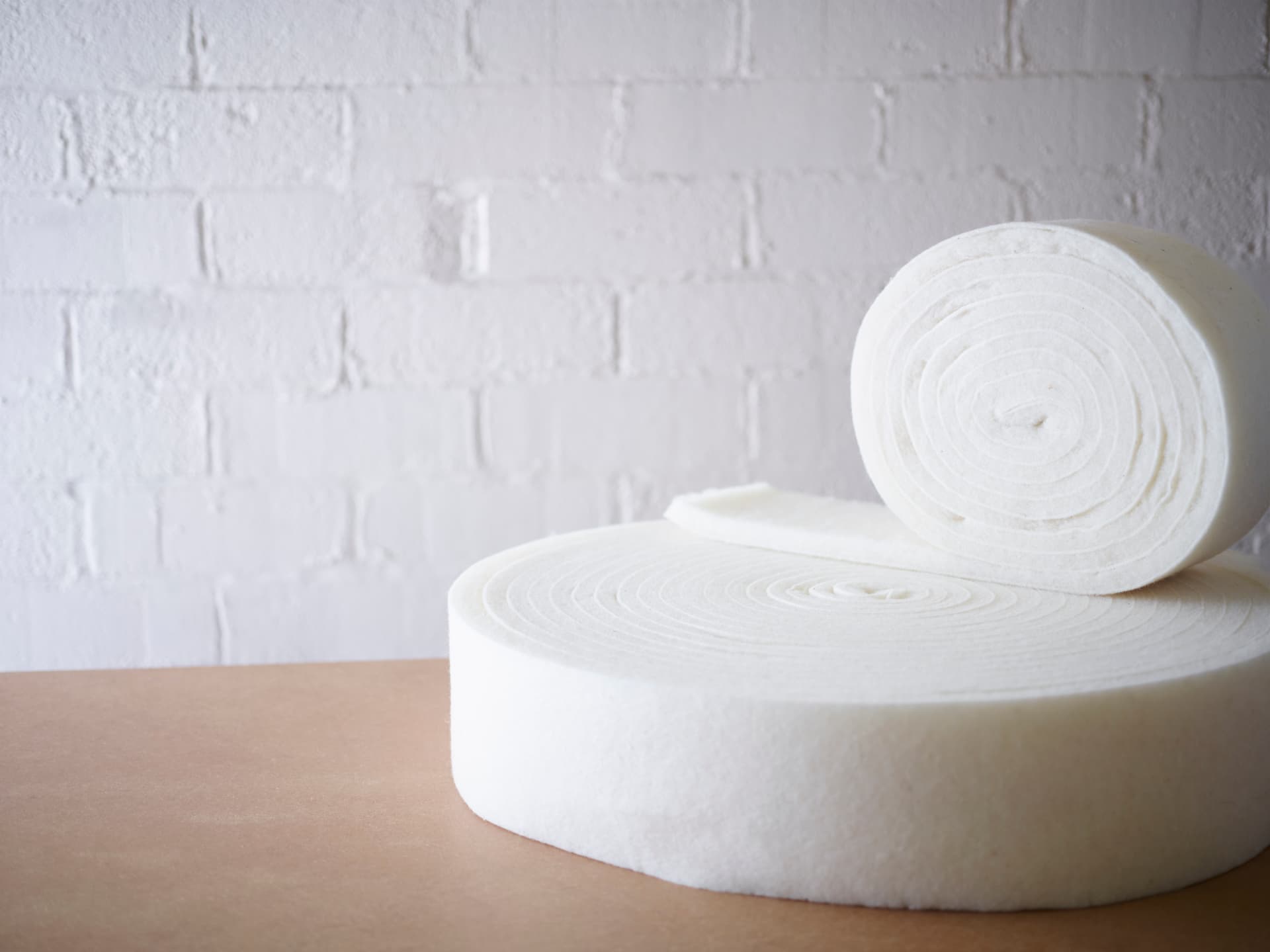Rolls of natural fibrous batting prepared by hand for the comfort layers of a Vispring mattress